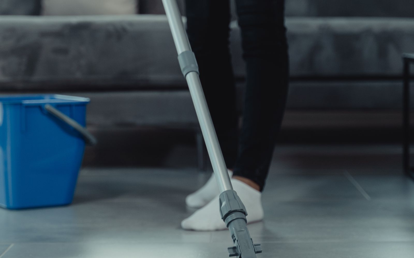 Cleaner maintaining a commercial floor with a mop and bucket